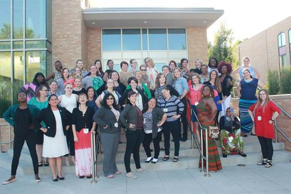 A group of people standing in front of a crowd posing for the camera

Description automatically generated